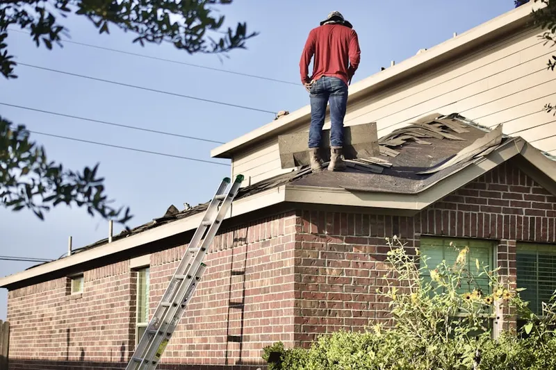 Professional roofer working on a residential roof in Huntingburg